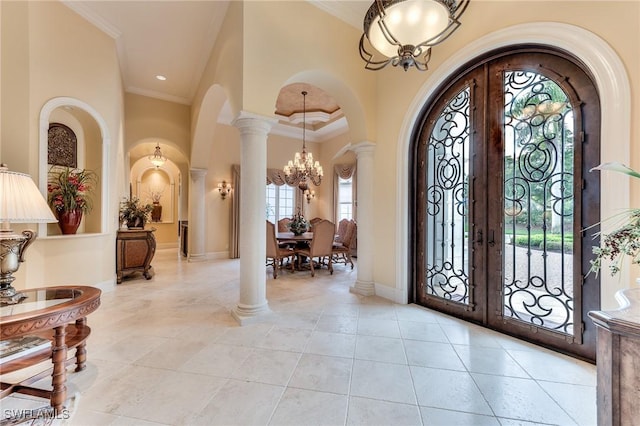 entryway featuring french doors, a notable chandelier, a wealth of natural light, and ornamental molding