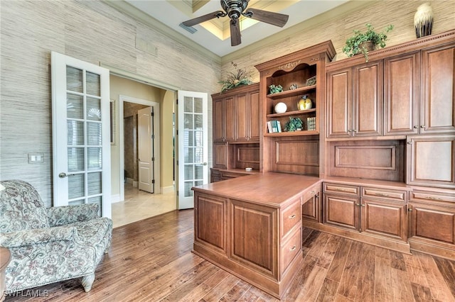 office area with ceiling fan, wood-type flooring, ornamental molding, and built in desk