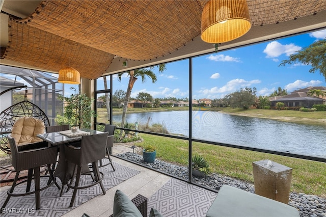 sunroom featuring lofted ceiling, a water view, and brick ceiling