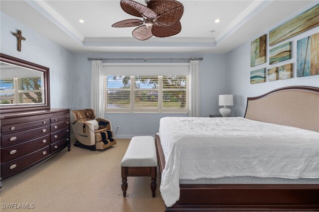 bedroom with ceiling fan, carpet, a tray ceiling, and ornamental molding