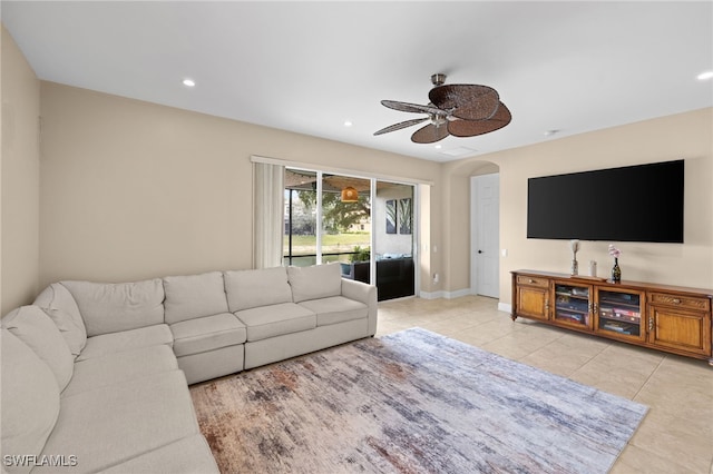 living area featuring a ceiling fan, arched walkways, baseboards, recessed lighting, and light tile patterned flooring