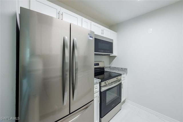 kitchen with light stone counters, white cabinets, and appliances with stainless steel finishes