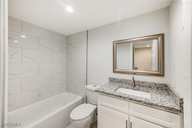 full bathroom featuring toilet, tiled shower / bath combo, and vanity