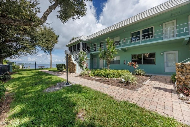 view of yard featuring a balcony and a water view