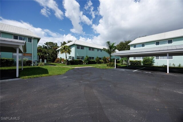 view of parking featuring a lawn and a carport