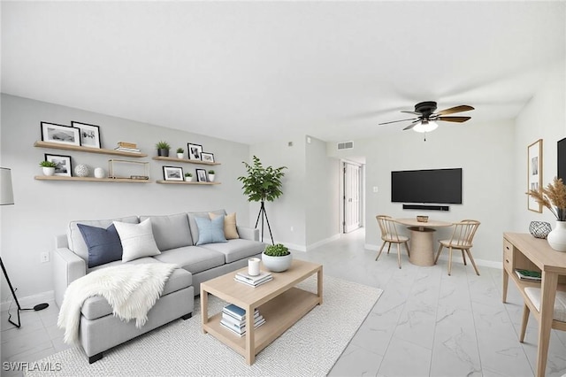 living area featuring visible vents, marble finish floor, and baseboards