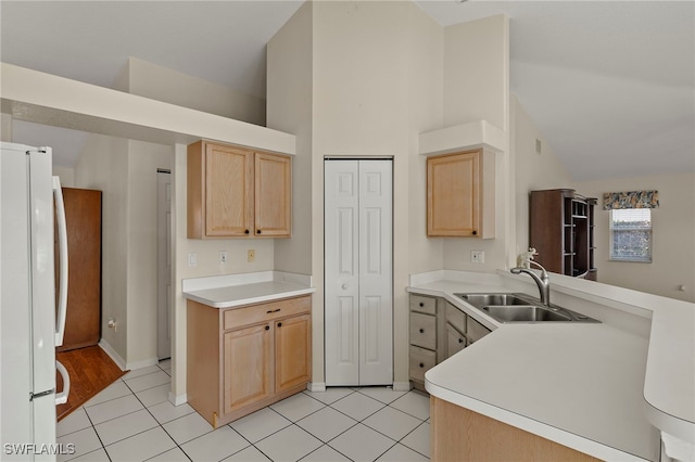 kitchen featuring white fridge, high vaulted ceiling, light brown cabinets, sink, and light tile patterned flooring