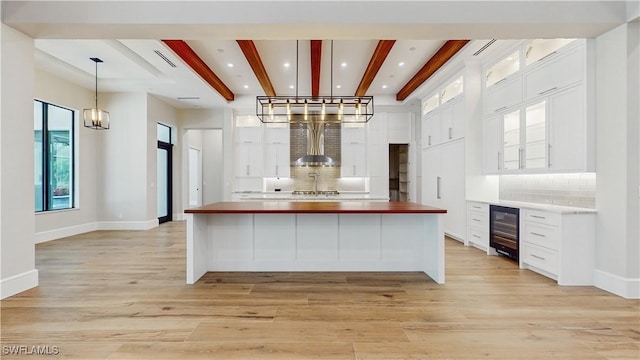 kitchen featuring white cabinetry, wine cooler, pendant lighting, and decorative backsplash