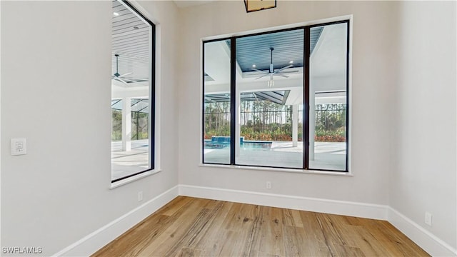 unfurnished room with ceiling fan, a wealth of natural light, and light hardwood / wood-style floors