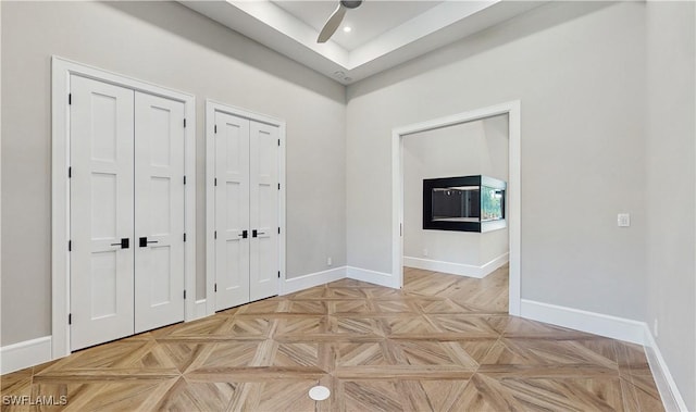 interior space with ceiling fan and light parquet floors