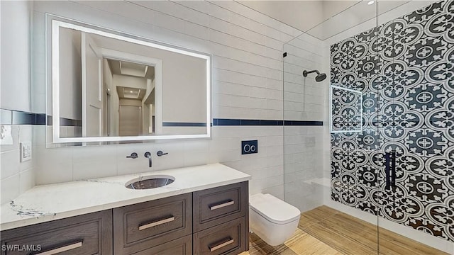 bathroom with vanity, toilet, tile walls, and tiled shower