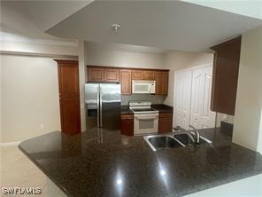 kitchen with sink, kitchen peninsula, and white appliances