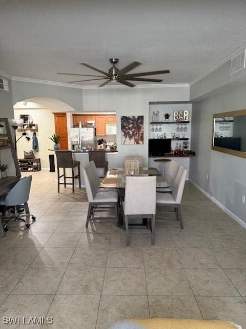 dining room featuring ceiling fan, ornamental molding, and light tile patterned floors