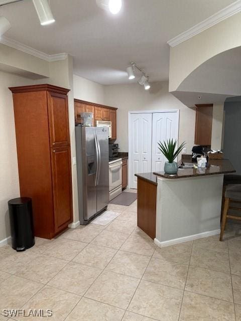 kitchen featuring a breakfast bar area, light tile patterned floors, kitchen peninsula, crown molding, and white appliances