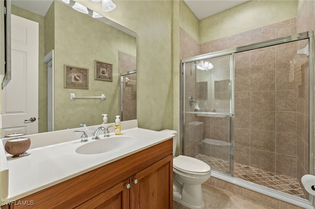 bathroom featuring vanity, an enclosed shower, tile patterned flooring, and toilet