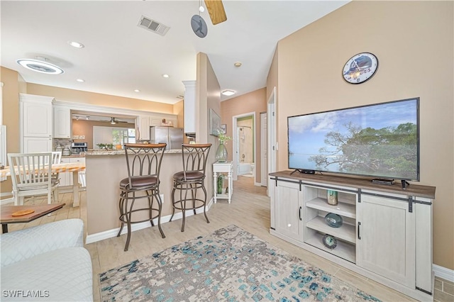 living room with ceiling fan and light hardwood / wood-style floors