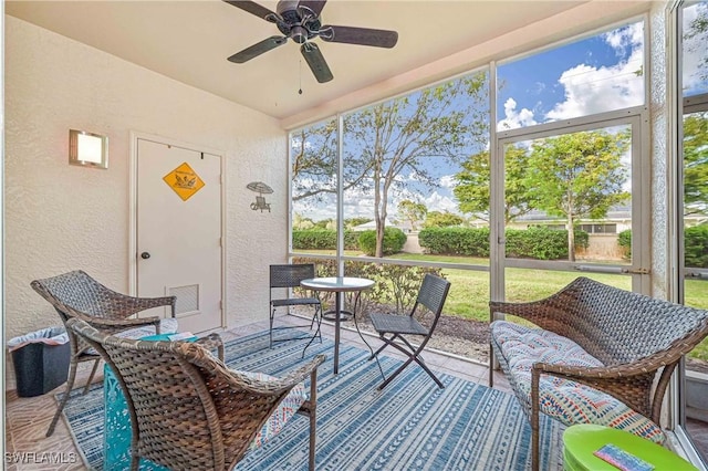 sunroom featuring ceiling fan and plenty of natural light