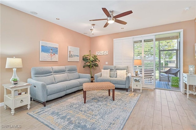 living room with ceiling fan and light hardwood / wood-style flooring