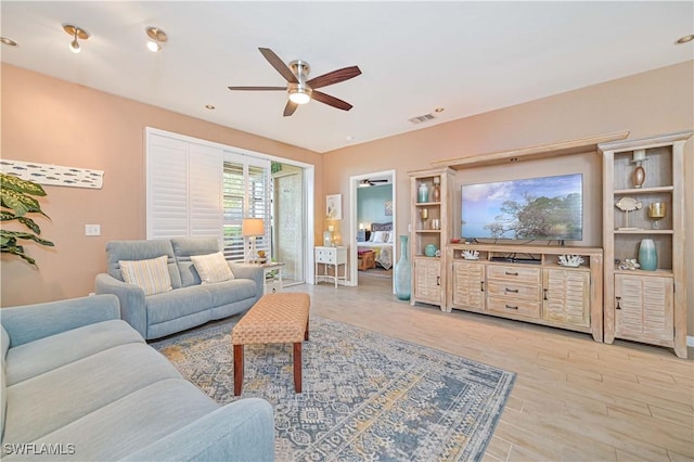 living room featuring ceiling fan and light wood-type flooring