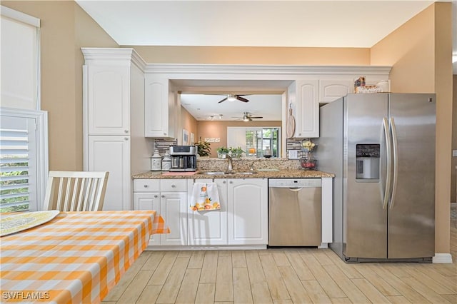 kitchen featuring white cabinets, stainless steel appliances, backsplash, and sink