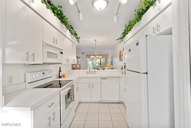 kitchen with white appliances, white cabinetry, light tile patterned floors, a chandelier, and rail lighting