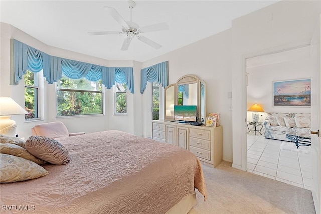 bedroom featuring ceiling fan, multiple windows, and light carpet