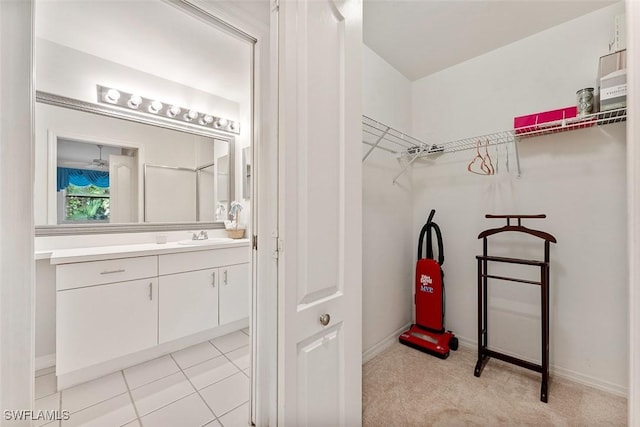 walk in closet with light carpet and sink