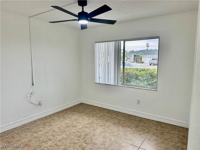 spare room with ceiling fan and light tile patterned flooring