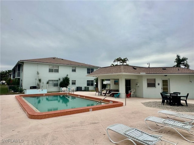 back of property featuring a patio area and a community pool