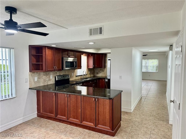 kitchen featuring stainless steel appliances, sink, backsplash, kitchen peninsula, and light tile patterned floors