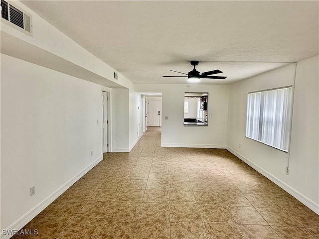 spare room with ceiling fan and a textured ceiling