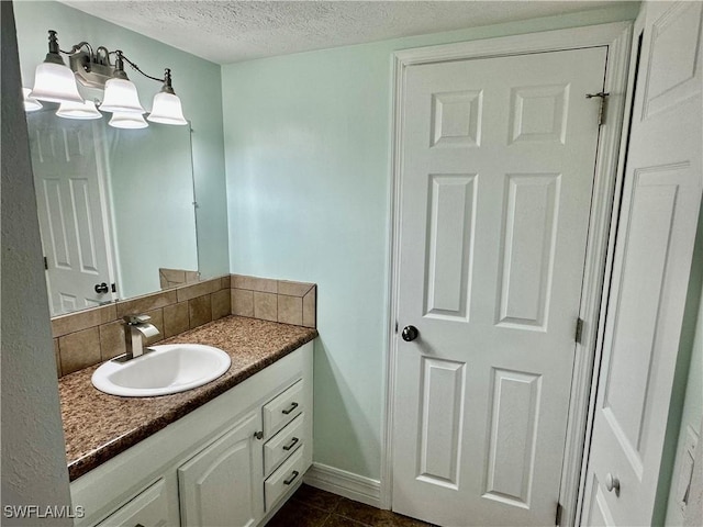 bathroom featuring tile patterned flooring, vanity, decorative backsplash, and a textured ceiling