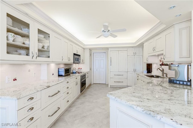 kitchen featuring sink, stainless steel appliances, a raised ceiling, and white cabinets