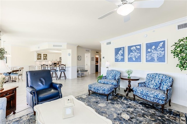 living room featuring crown molding, tile patterned floors, and ceiling fan