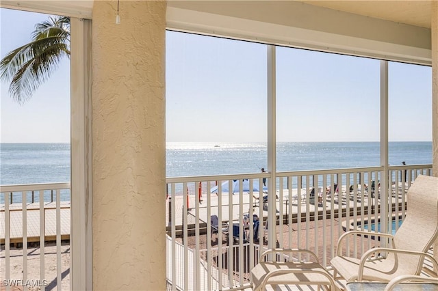 sunroom with a beach view and a water view