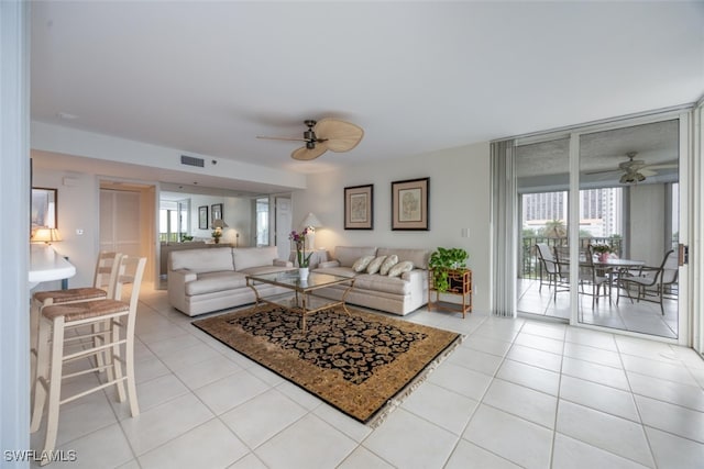 living area featuring light tile patterned floors, visible vents, and a ceiling fan