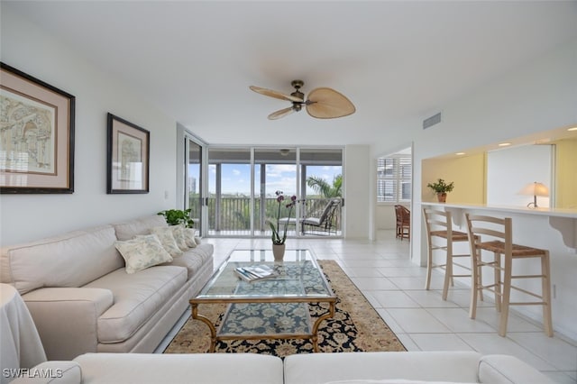 living area with visible vents, floor to ceiling windows, ceiling fan, and light tile patterned flooring