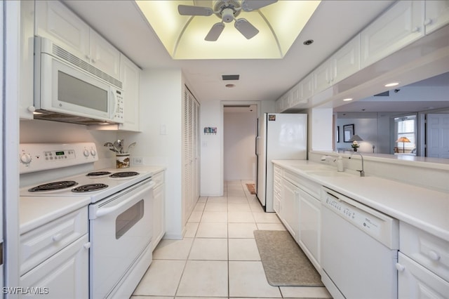 kitchen featuring light tile patterned floors, light countertops, white cabinets, a sink, and white appliances