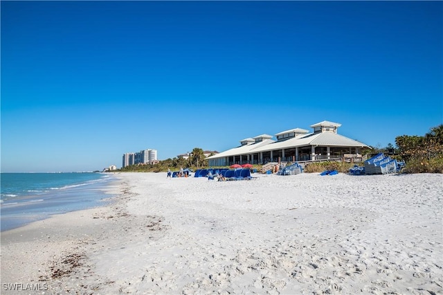 exterior space featuring a water view and a beach view