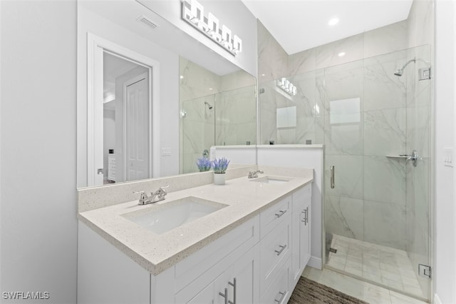 bathroom featuring a shower with door and vanity