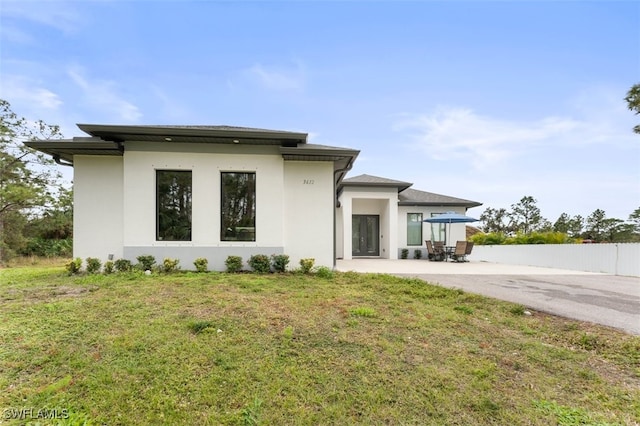 rear view of house featuring a patio area and a yard