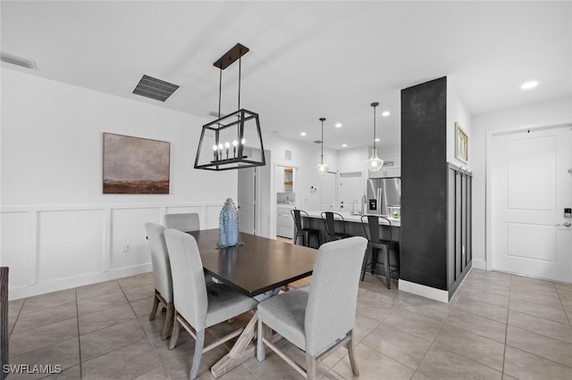 dining space featuring sink and a notable chandelier