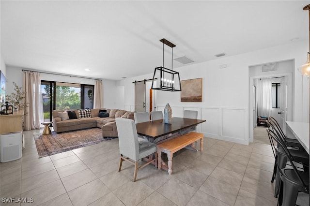 dining area featuring light tile patterned floors and a barn door