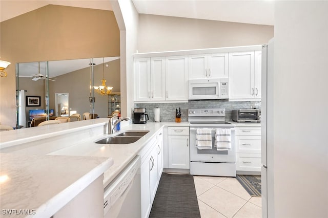 kitchen with lofted ceiling, sink, white cabinets, and white appliances