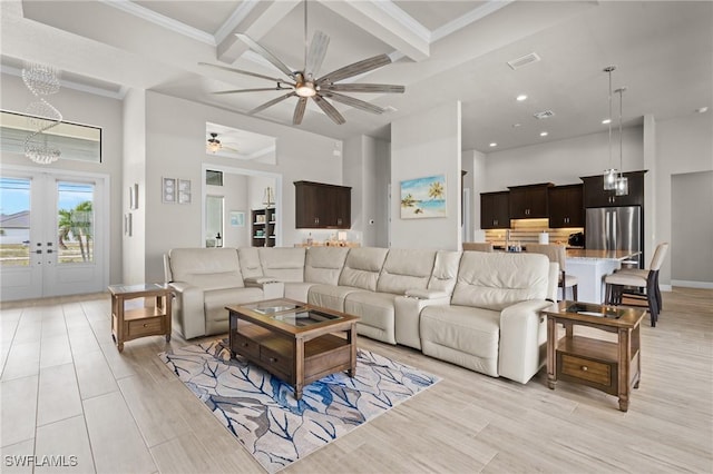 living room featuring coffered ceiling, beam ceiling, a towering ceiling, french doors, and ceiling fan with notable chandelier