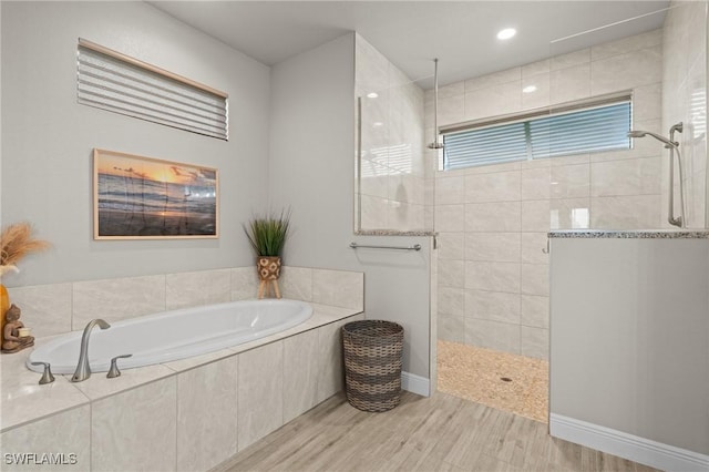 bathroom with hardwood / wood-style floors and separate shower and tub