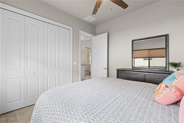 bedroom with light wood-type flooring, ceiling fan, and a closet