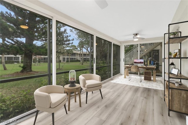 sunroom featuring ceiling fan and a baseboard heating unit