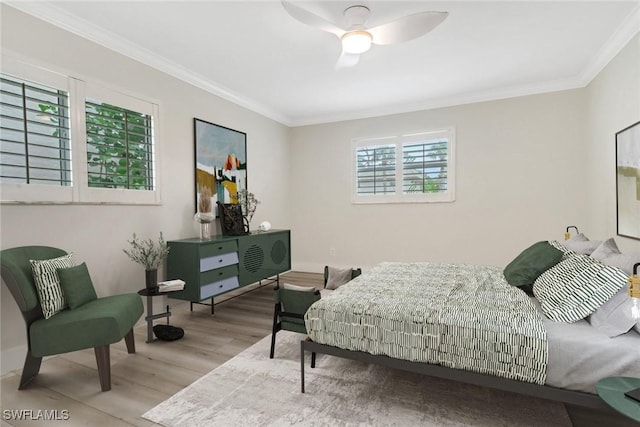 bedroom featuring light wood-type flooring, ceiling fan, and crown molding