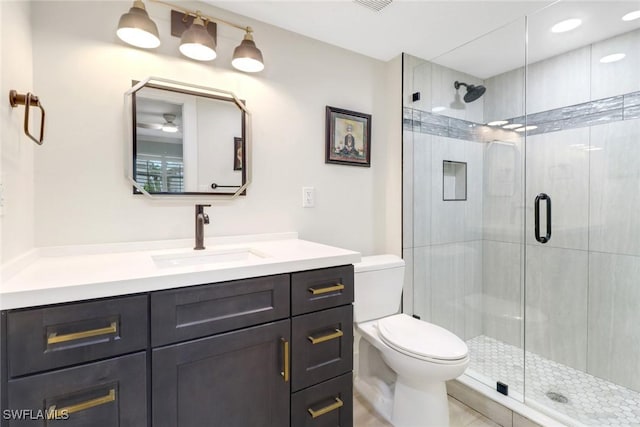 bathroom with a shower with door, tile patterned floors, toilet, and vanity